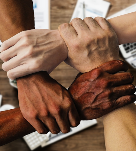 Photo of four people holding each other's wrists forming a square, reinforcing each other